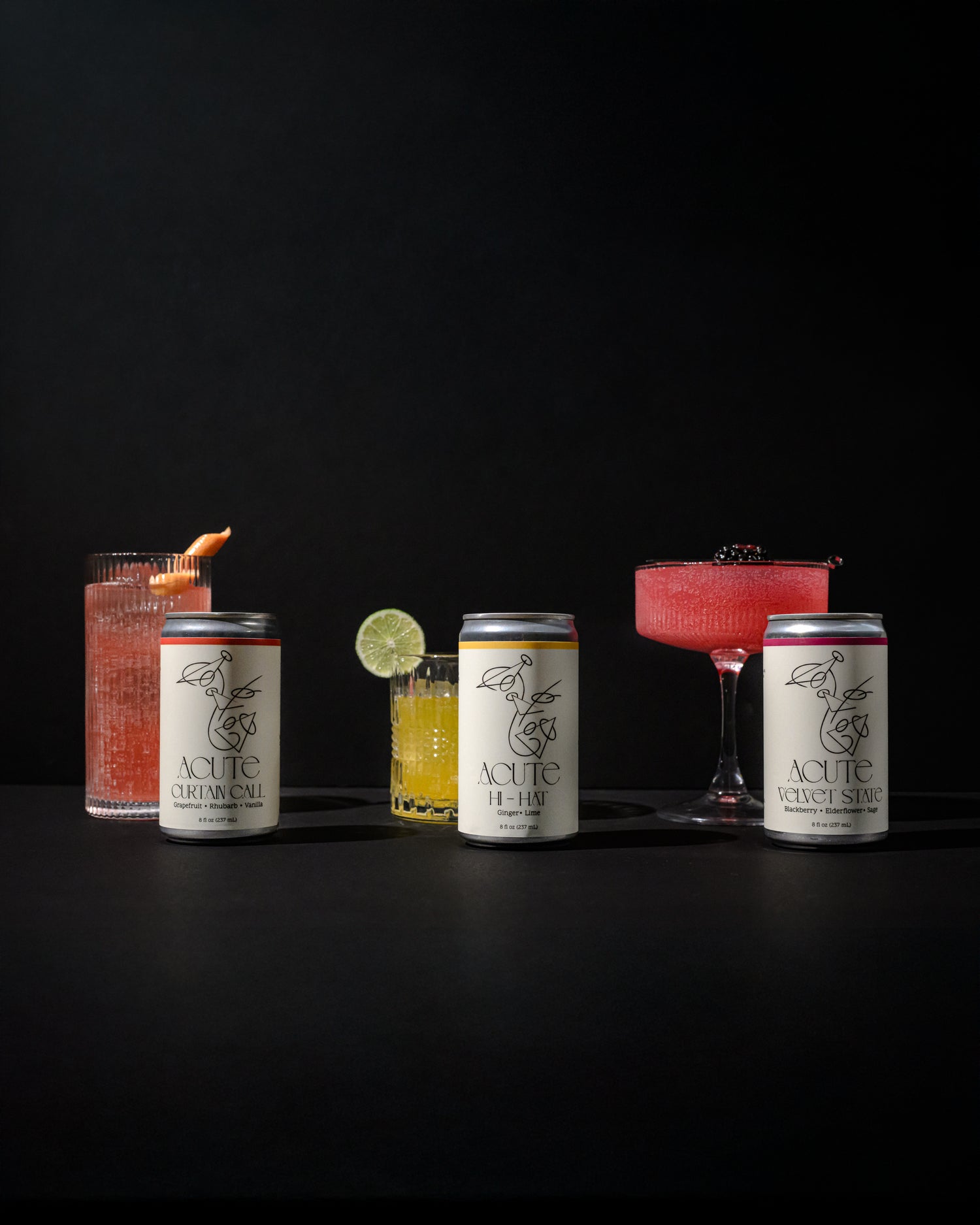Can of ACUTE Curtain Call, Hi-Hat, and Velvet State with garnished glasses on black background